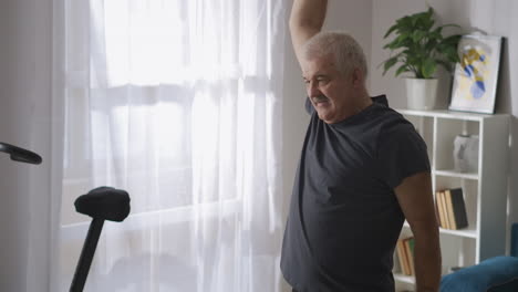 adult-man-with-moustache-is-doing-gymnastics-at-home-at-morning-healthy-lifestyle-for-elderly-people-keeping-health-of-body